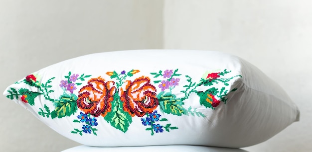 haftowana poduszka z roślinnym motywem